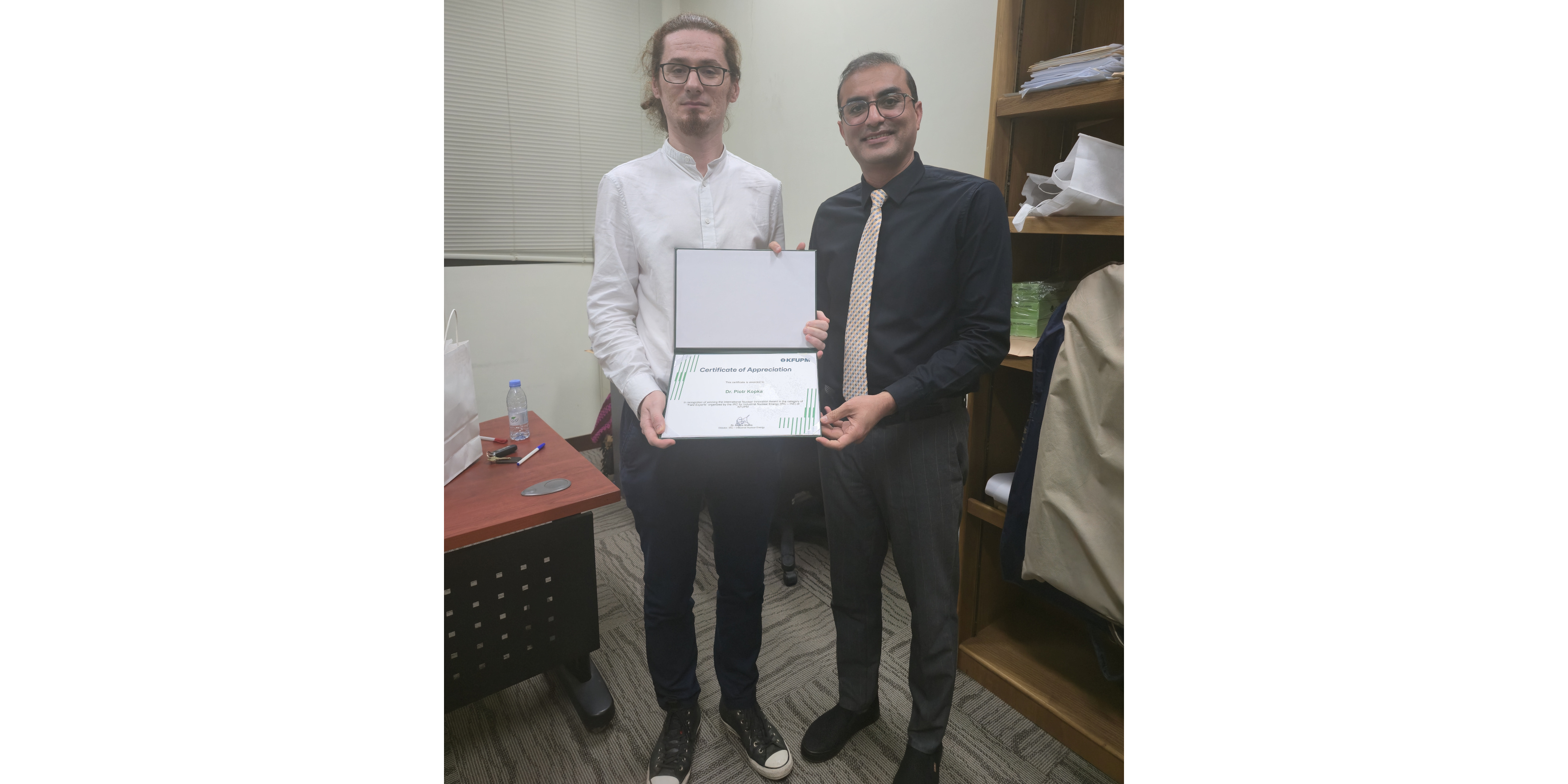 Dyrektor Centrum, Prof. Afaque Shams, wręcza dr Piotrowi Kopce nagrodę oraz pamiątkowy dyplom